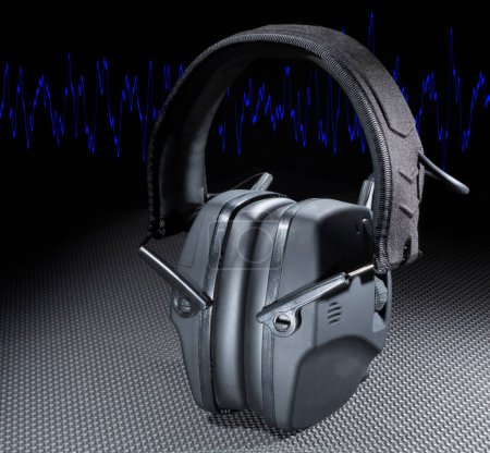 Blue sine wave behind electronic headphones that provide hearing protection for shooting or construction
