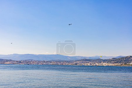 Photo for View of Cannes from the sea, two helicopters fly over the coast. Vue sur Cannes depuis la mer, deux helicopteres survolent la cote. - Royalty Free Image