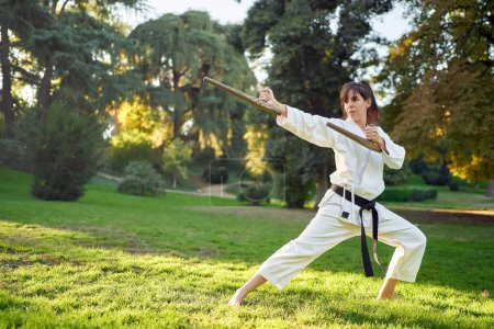 Photo for Martial arts teacher in white kimono is practicing with tonfa. High quality photo - Royalty Free Image