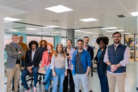 Un grupo diverso de profesionales sonriendo y posando juntos en un espacio contemporáneo de oficina de coworking. 