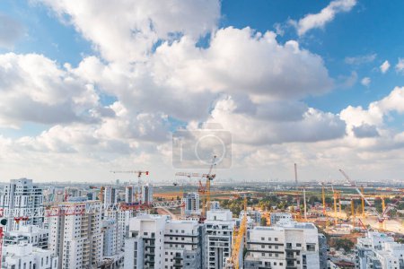 Téléchargez les photos : Rishon LeZion, Israël, 20 septembre 2023. Panorama d'un grand nombre de grues à tour, et développement de nouveaux appartements de grande hauteur dans le contexte d'un ciel bleu et de beaux nuages blancs - en image libre de droit