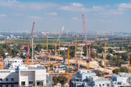 Téléchargez les photos : Rishon LeZion, Israël, 20 septembre 2023. Panorama d'un grand nombre de grues à tour, et développement de nouveaux appartements de grande hauteur dans le contexte d'un ciel bleu et de beaux nuages blancs - en image libre de droit