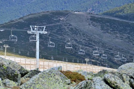 Photo for Chairlifts and ski slopes of Valdesqui in Navacerrada, Spain. Ski facilities in spring after the ski season with the forests of the National Park in the background. - Royalty Free Image