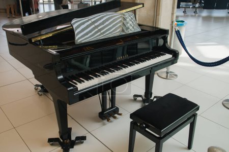 Photo for Bari, Italy. 07 04 2019. Black piano of the yamaha brand. Piano located in the departure lounge of the Bari-Palense airport, Aeroporto Internazionale di Bari-Karol Wojtyla. - Royalty Free Image