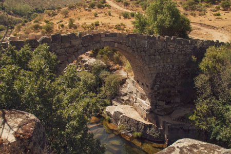 Téléchargez les photos : Pont romain sur la rivière Barbellido à Navacepeda de Tormes à Avila, Espagne. Pont en pierre qui traverse la flaque ou la piscine connue sous le nom de Poza de las Paredes. - en image libre de droit
