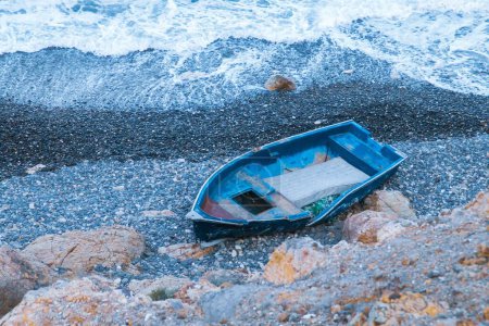 Téléchargez les photos : Vieux bateau échoué sur une plage de gravier. Vieux bateau de pêche traditionnel abandonné sur une plage à Almeria, Espagne. - en image libre de droit