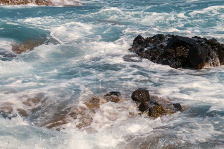 Foto de Olas marinas rompiendo en las rocas cerca de la costa. Mar Mediterráneo en la cala de Los Amarillos en Nijar, Almería, España. - Imagen libre de derechos