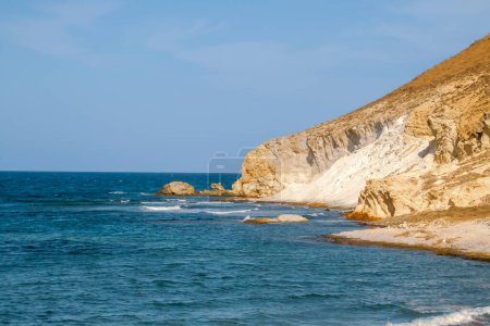 Foto de Acantilados junto a la cala de Los Amarillos en el Mar Mediterráneo. Costa con fuerte luz solar al sur de la playa. Nijar, España. - Imagen libre de derechos