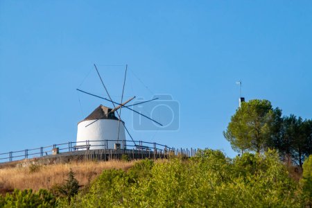 Traditionelle Windmühle auf einem Hügel an einem klaren Tag in Sanlucar de Guadiana, Spanien. Restaurierte traditionelle Mühle mit ihren weiß getünchten Wänden und dem typischen kegelförmigen Dach.