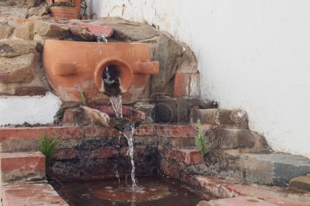 Fountain through which a slight trickle of water runs in Sanlucar de Guadiana, Spain. Fountain made of traditional clay basins. Located on Cabezo Street.