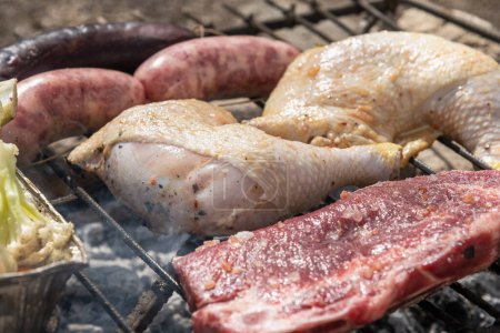 Photo for Sausages, steaks, chicken thighs and cauliflower grilling outdoors - Royalty Free Image