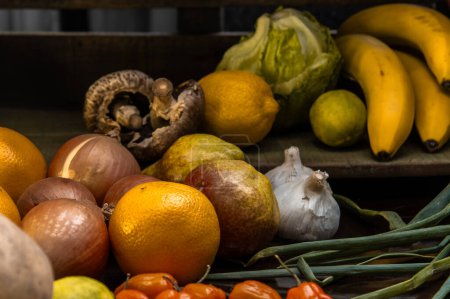 Foto de Frutas y verduras naturales sobre un fondo oscuro, lechuga, lem - Imagen libre de derechos