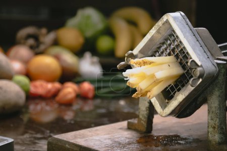 Téléchargez les photos : Machine manuelle avec grille tranchante pour couper les pommes de terre ou les légumes - en image libre de droit
