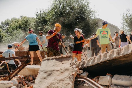 Foto de 06.08.2022 Irpin, Ukraine: a group of volunteers is sorting through the rubble of a house destroyed by Russian missiles. Reconstruction of civilian houses destroyed by Russian missiles and drones - Imagen libre de derechos