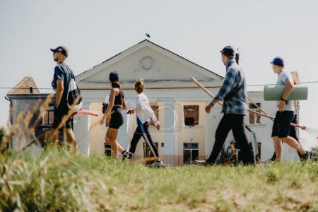 Foto de 06.08.2022 Irpin, Ukraine:  a group of volunteers is moving in the direction of the house destroyed by the Russian troops to carry out dismantling and restoration of the lost housing - Imagen libre de derechos