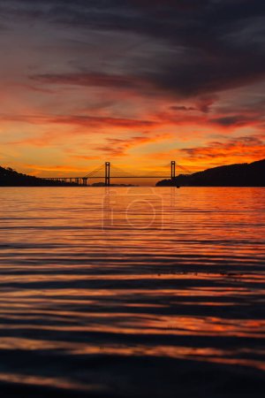 Foto de Vista del puente Rande y el estuario de Vigo desde la playa de cesantes en una increíble puesta de sol naranja en Galicia - Imagen libre de derechos