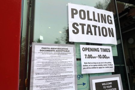 Carteles de centros de votación del Reino Unido, incluidos horarios de apertura y documentos de identificación con foto aceptables