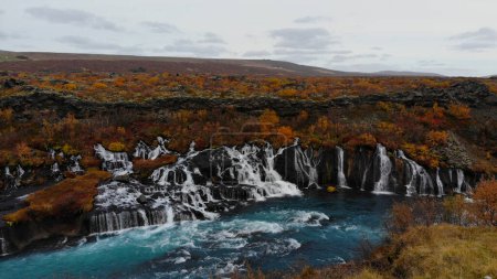 Foto de Hraunfossar (Borgarfjordur, oeste de Islandia) es una serie de cascadas formadas por arroyos que fluyen a una distancia de unos 900 metros de la - Imagen libre de derechos