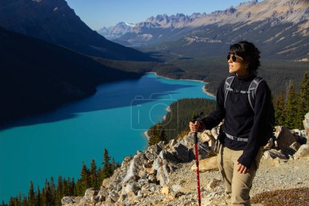 Téléchargez les photos : Femme randonneuse avec bâton de randonnée. Par une journée d'automne claire et ensoleillée au magnifique lac Peyto avec de l'eau turquoise. - en image libre de droit