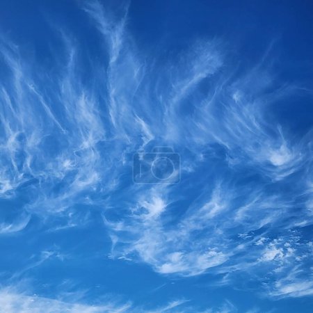 revoloteando delicadas nubes de cirros en el brillante cielo azul
