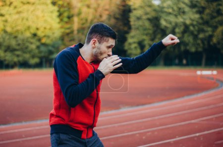 Photo for A man in a sweatshirt boxing alone - Royalty Free Image