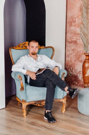 Photo for A man sits in a chair with a magazine - Royalty Free Image
