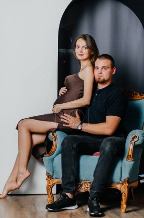 Photo for A pregnant woman and a man are sitting in a chair - Royalty Free Image