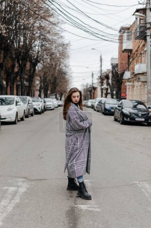 Photo for The girl is standing on the street in a gray coat - Royalty Free Image