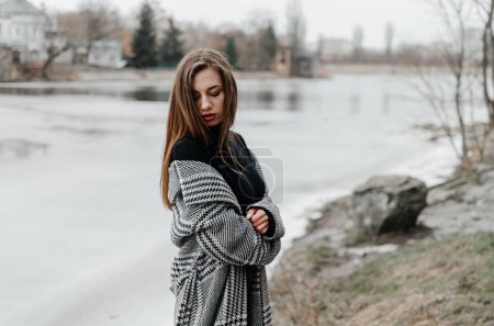 Photo for A woman stands by a frozen river - Royalty Free Image