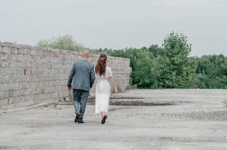 Photo for The bride and groom walk down the road - Royalty Free Image