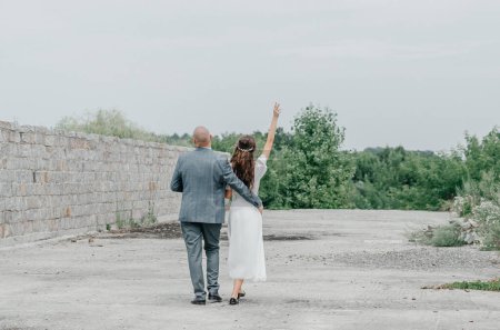 Téléchargez les photos : Les mariés marchent sur la route - en image libre de droit