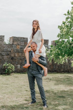 Photo for The groom holds the bride on his shoulders - Royalty Free Image