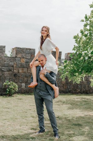 Photo for The groom holds the bride on his shoulders - Royalty Free Image