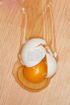 Photo for Broken egg on the wooden floor at kitchen - Royalty Free Image
