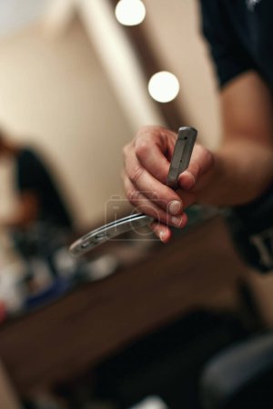 Téléchargez les photos : Main de barbier tester la netteté de la lame avant de couper
. - en image libre de droit