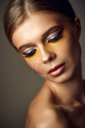 Photo for Gorgeous blonde model girl with fashionable creative make-up, bright eye line. Creative yellow eye makeup ideas. - Royalty Free Image