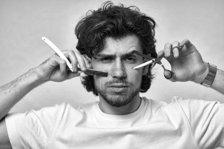 Téléchargez les photos : Portrait of barber with sharp blade before cutting. black and white - en image libre de droit