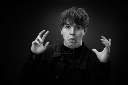Foto de Portrait of crazy young man showing the tongue and grimacing . black and white - Imagen libre de derechos