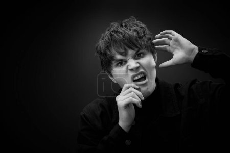 Foto de Portrait of crazy young man with awesome hairdo grimacing and yelling with a violent or desperate face. black and white - Imagen libre de derechos