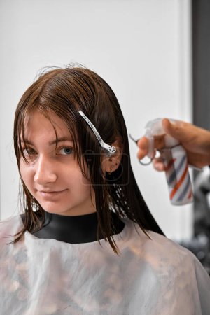 Foto de Professional male hairdresser cutting female hair in salon - Imagen libre de derechos