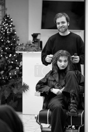 Téléchargez les photos : Beautiful young woman in modern hair salon. hairdresser checking hairstyle of caucasian girl - en image libre de droit