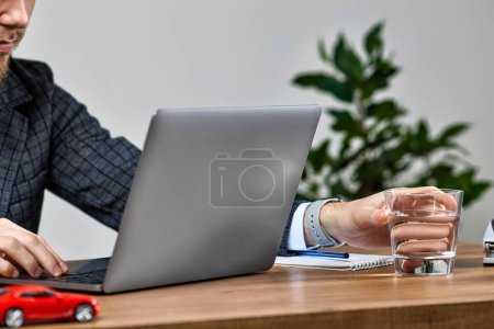 Téléchargez les photos : Homme d'affaires travaillant sur ordinateur portable. Mains masculines tapant sur un clavier d'ordinateur portable sur un bureau en bois. Gros plan - en image libre de droit