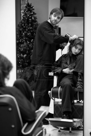 Téléchargez les photos : Belle jeune femme dans le salon de coiffure moderne. coiffeur vérification coiffure de caucasien fille - en image libre de droit