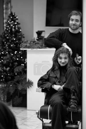 Téléchargez les photos : Beautiful young woman in modern hair salon. hairdresser checking hairstyle of caucasian girl - en image libre de droit
