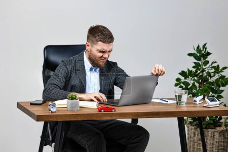 Photo for Irritated angry businessman shouting sitting at desk work on laptop pc computer - Royalty Free Image