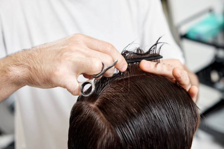 Photo for Close-up, professional male hairstylist does haircut for client man at barber shop. - Royalty Free Image