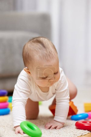 Photo for Cute baby girl playing with colorful toy blocks at home - Royalty Free Image