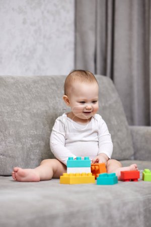 Photo for Cute baby girl playing with colorful toy blocks at home - Royalty Free Image