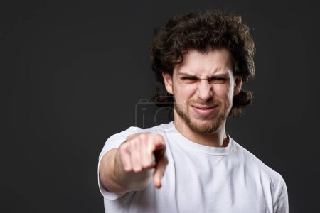Photo for Amazed caucasian man pointing finger at you on dark gray background - Royalty Free Image