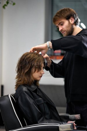 Foto de Male hairdresser working with client at the beauty salon - Imagen libre de derechos